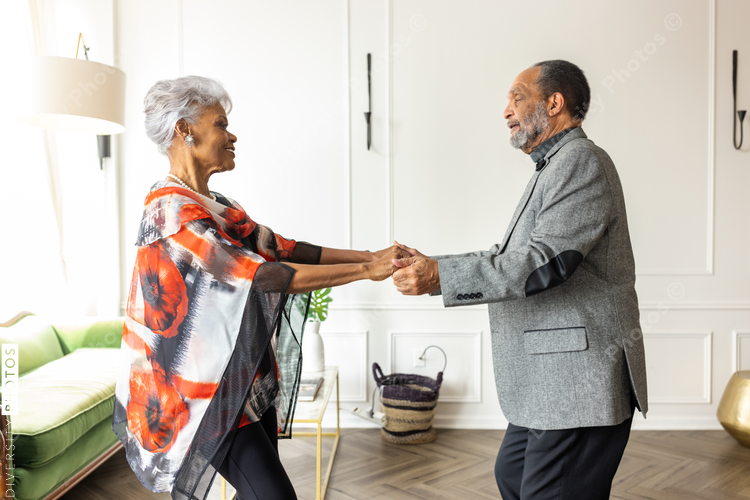 Smiling Black senior couple dancing at home, love and connectedness