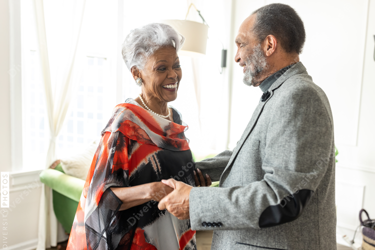 Smiling Black senior couple dancing at home, love and connectedness
