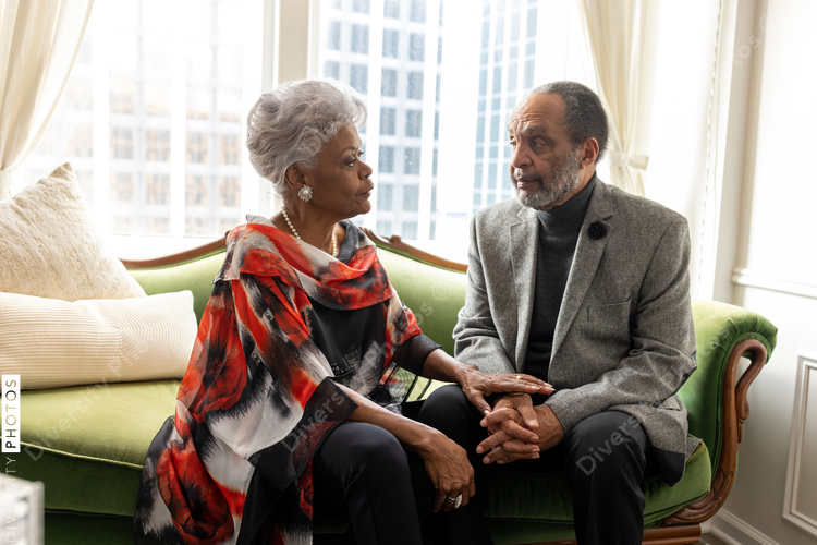 Black senior couple embracing, celebrating their love, holding hands at home