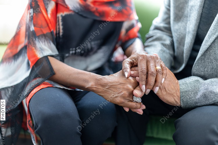 Black senior couple embracing, celebrating their love, holding hands at home