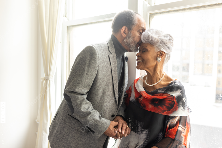 Senior man kisses wife on forehead, loving moments